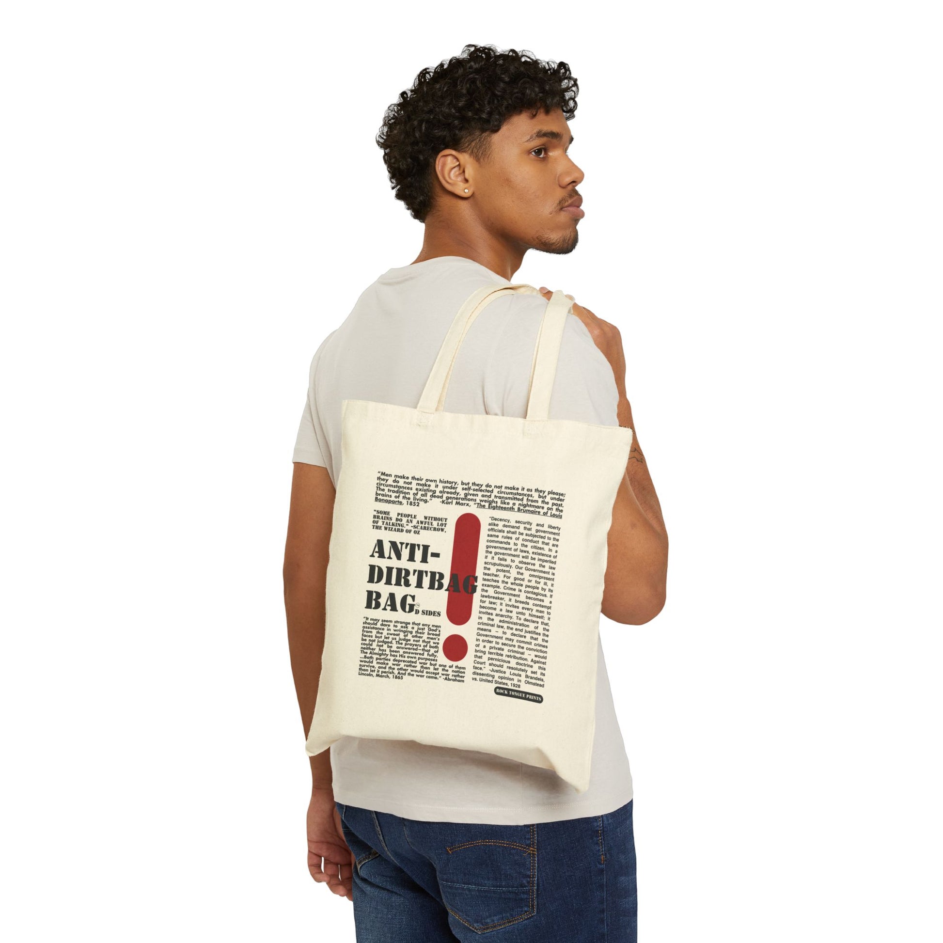 Picture of a man holding a cotton canvas tote over his shoulder with large-text words "Anti-Dirtbag Bag, D Sides " a large red exclamation point, and smaller-text, social justice oriented quotes by Abraham Lincoln, Justice Louis Brandeis, and others.